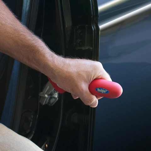 Close-up of the HandyBar's sturdy metal tip securely placed in a U-shaped door latch striker.